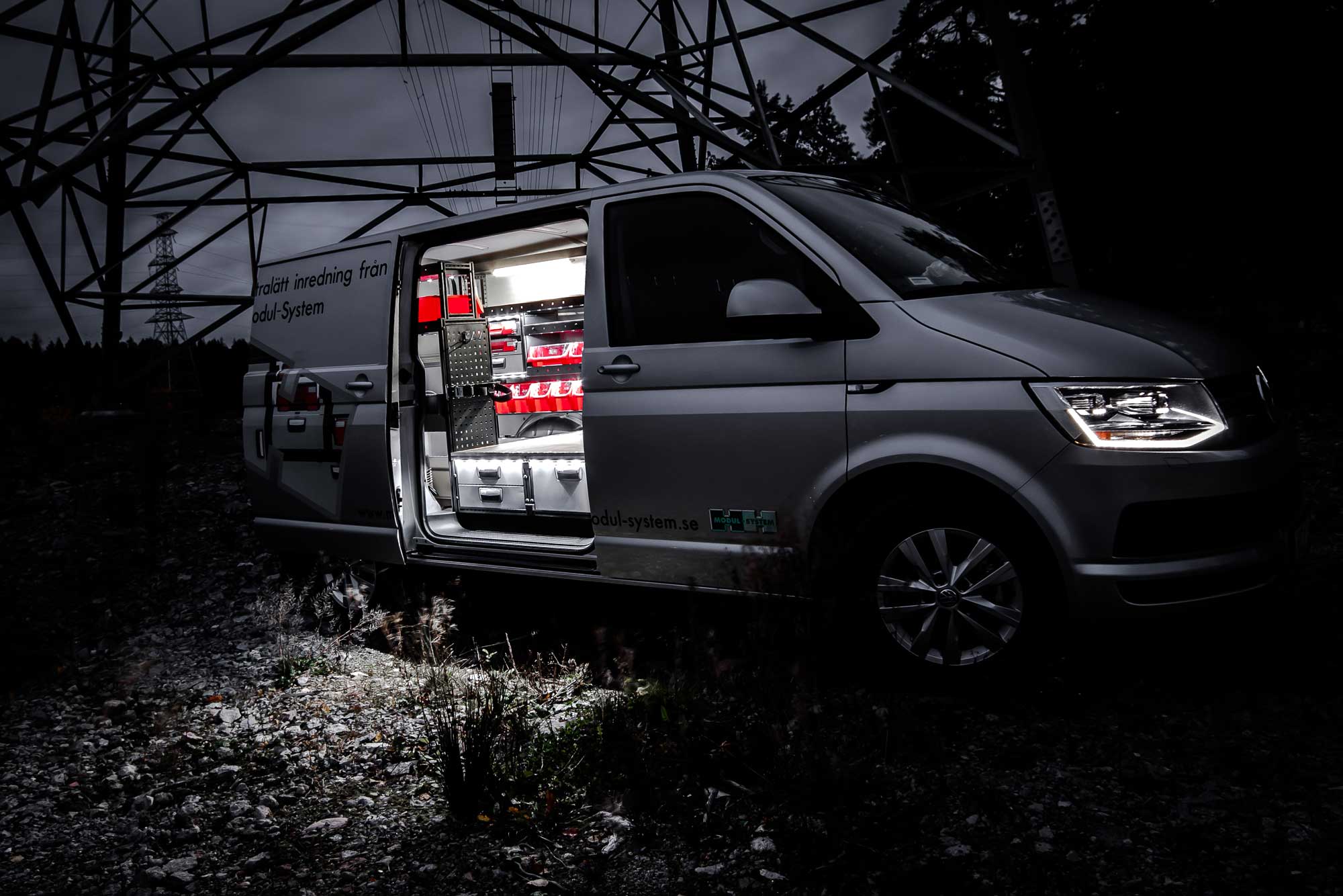 Electricien bedrijfswagen 's avonds voorzien van modul-system bedrijfswageninrichting, in het veld bij een electriciteitspaal